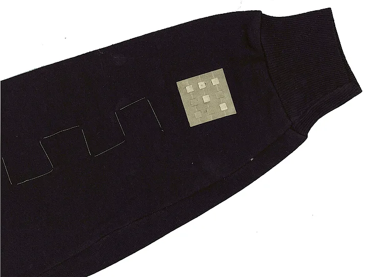 A touchpad sewn into a jacket sleeve with conductive fabric; conductive thread doubles as the antenna.